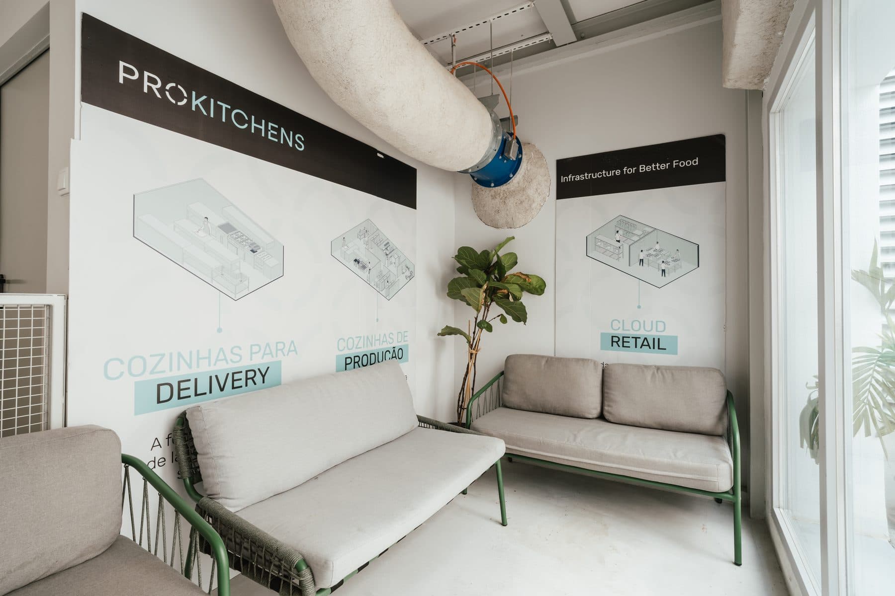 Sala de descanso com dois sofás, junto à parede com a marca ProKitchens