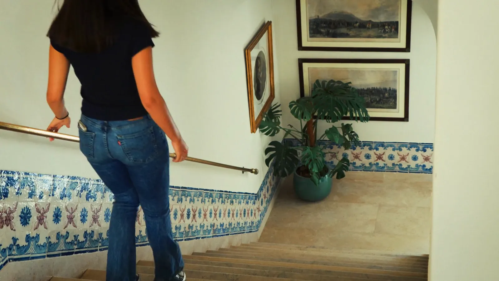 Hóspede a subir a escada com azulejos azuis do Hotel Casa Palmela