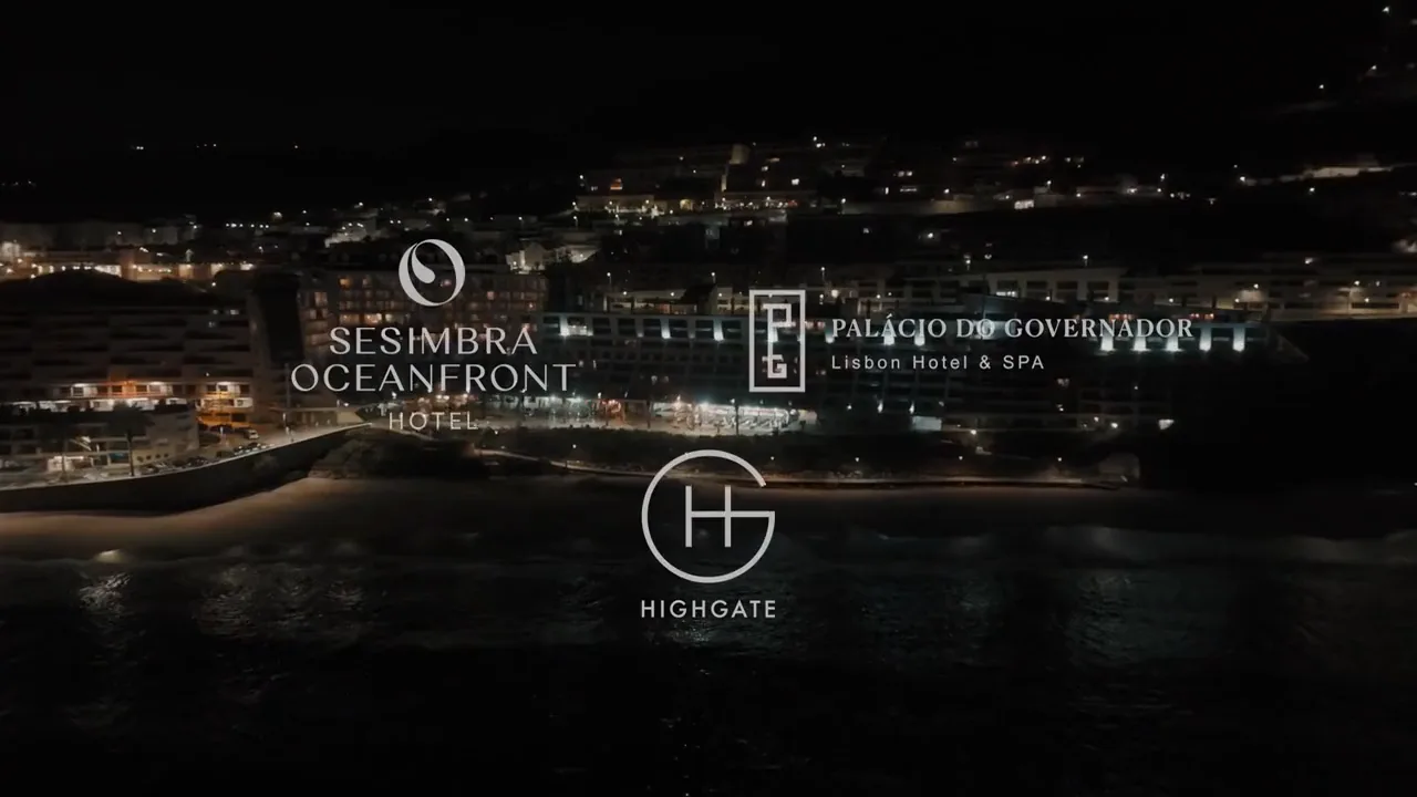 Os logótipos dos hotéis e da Highgate sobre Sesimbra à noite