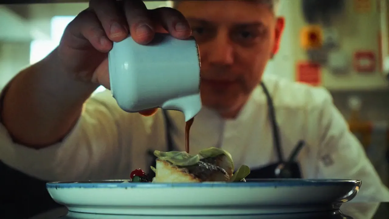Sauce being poured onto the plate in the Sóçe kitchen