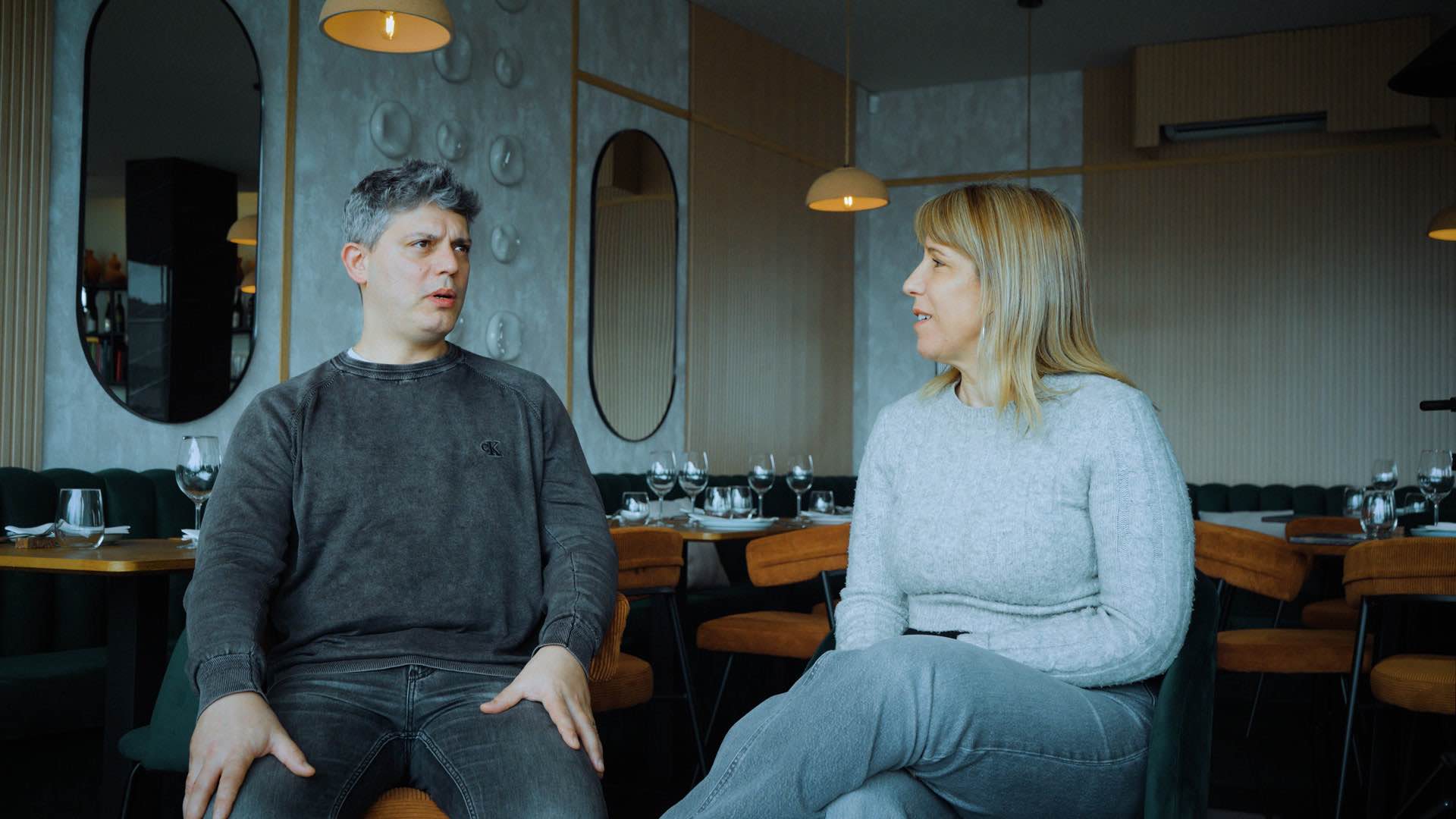 Duas pessoas sentadas à conversa numa sala de restaurante, durante uma entrevista